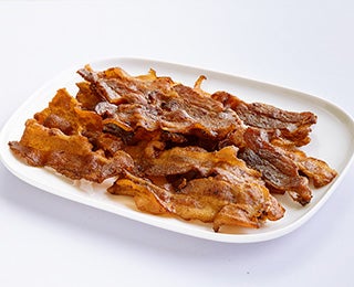 Tiras de bacon frito sobre un plato