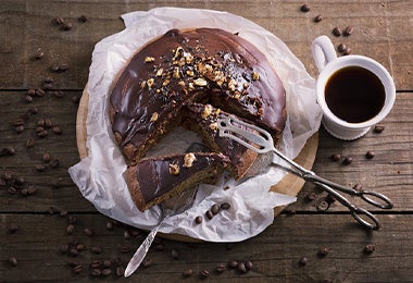 Chocolate derretido en un bowl y un ponqué de chocolate para preparar una Tarta Sacher