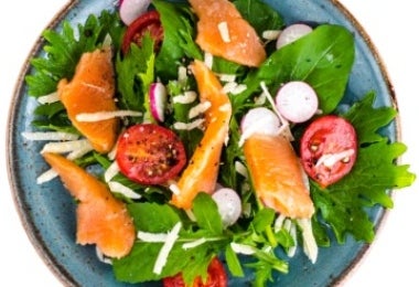 Ensalada de salmón ahumado en caliente con tomate y lechuga.