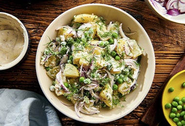 Ensalada de verduras, hierbas, papa y cebolla en plano cenital.