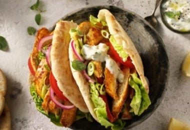 Gyro de pollo estilo griego con lechuga, tomate, cebolla y salsa tzatziki