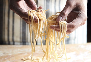 Persona preparando masa de pasta fresca de colores