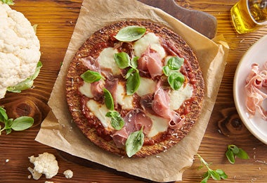 Pizza de prosciutto con rúcula y coliflor