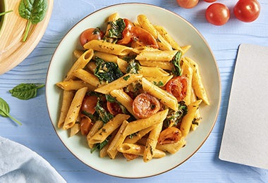 Plato de pasta y espinaca con tomates confitados