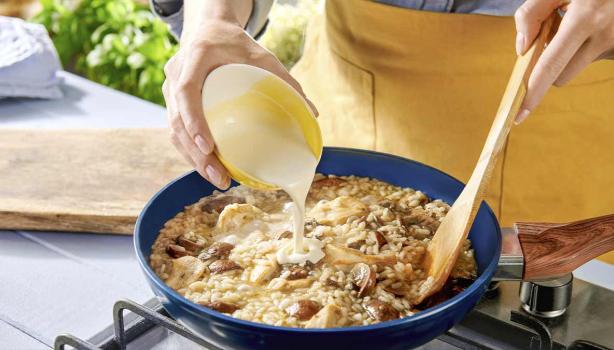 Una persona preparando una receta de cocción lenta con hongos, crema y arroz