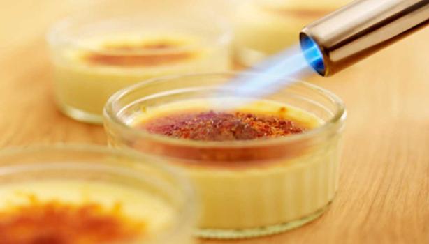 Soplete de cocina caramelizando la superficie de un flan