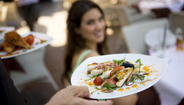 Exquisito y elegante platillo de cualquiera de los tipos de calamar con vegetales siendo llevado a la mesa.