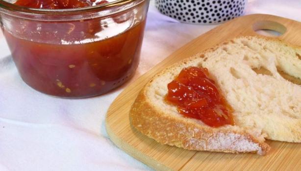 Rebanada de pan con mermelada casera de fresa, recipiente de vidrio sobre tabla