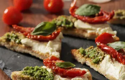 Crostinis con Queso Crema, Tomates y Pesto