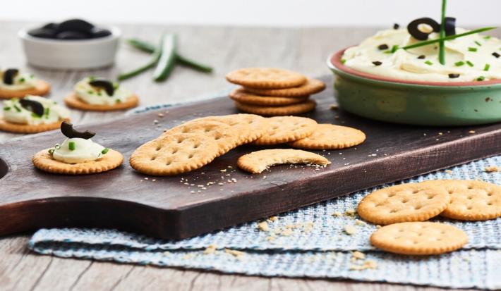 Receta dip de queso crema, aceitunas y cebollin con galletas Ricas®.